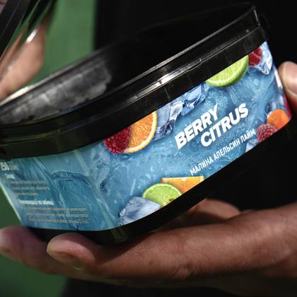 Банка табака Berry Citrus в руках кальянного мастера
